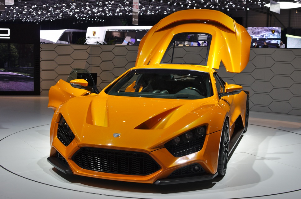 Orange hypercar with open gullwing doors and aggressive aerodynamic design