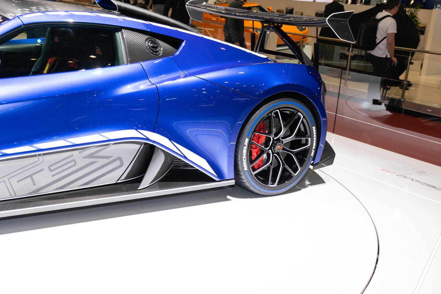 Rear side with large carbon fiber wing, sculpted body, and sporty wheel