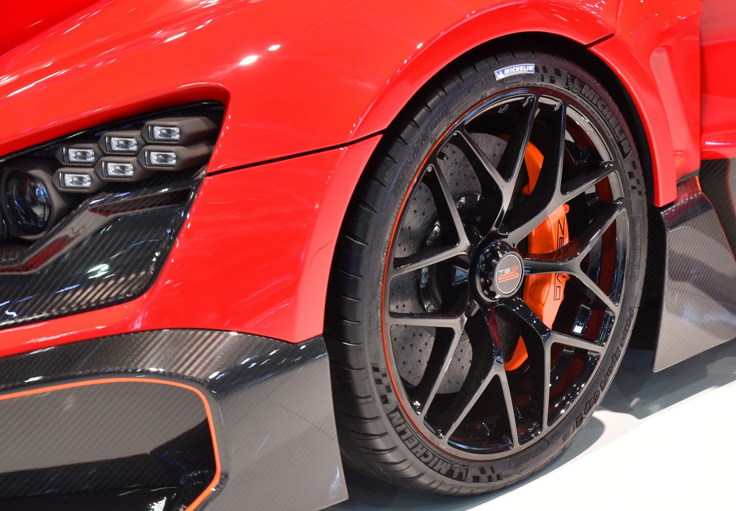 Close-up of sports wheel and LED headlights with carbon fiber trim