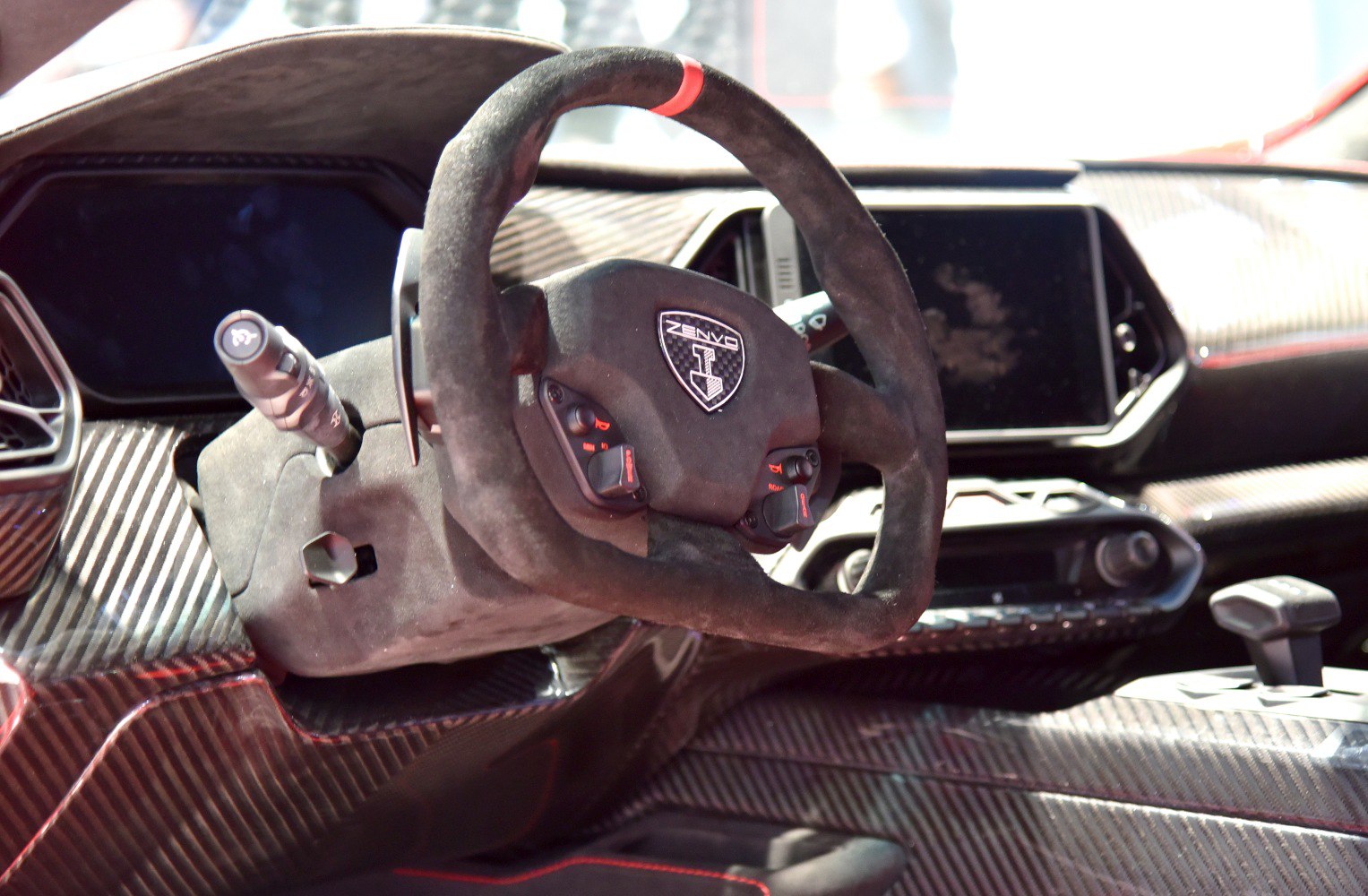 Racing steering wheel and carbon fiber dashboard in a high-performance sports interior