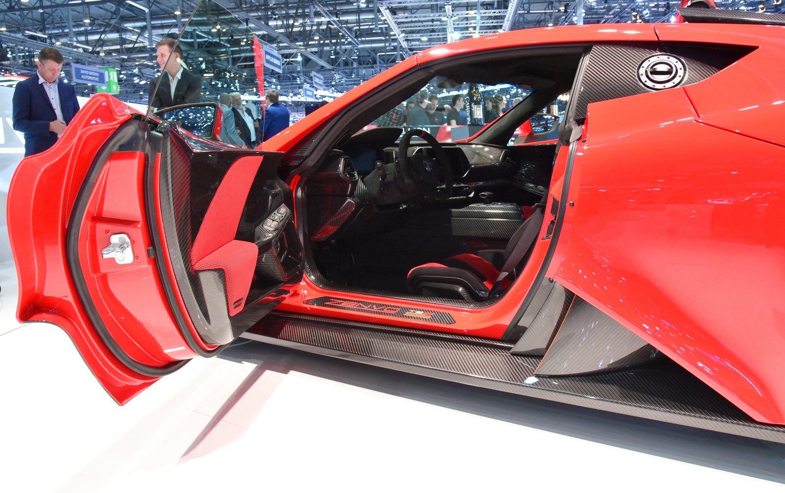 Open car door with carbon fibre trim and sporty interior details.
