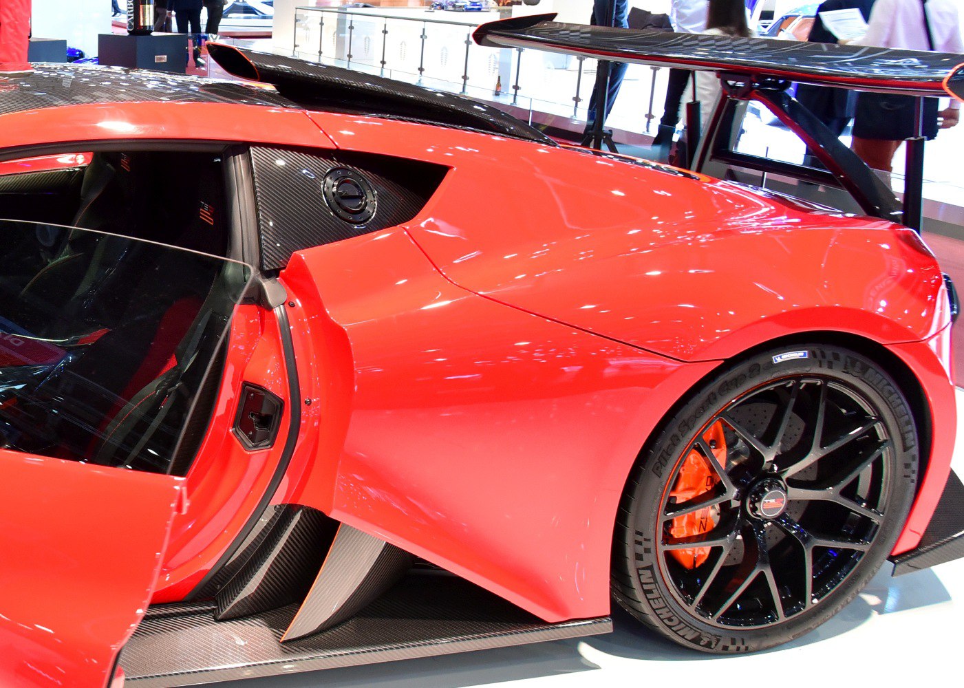 Hypercar rear side with carbon fiber, aero wing, and black multi-spoke wheel