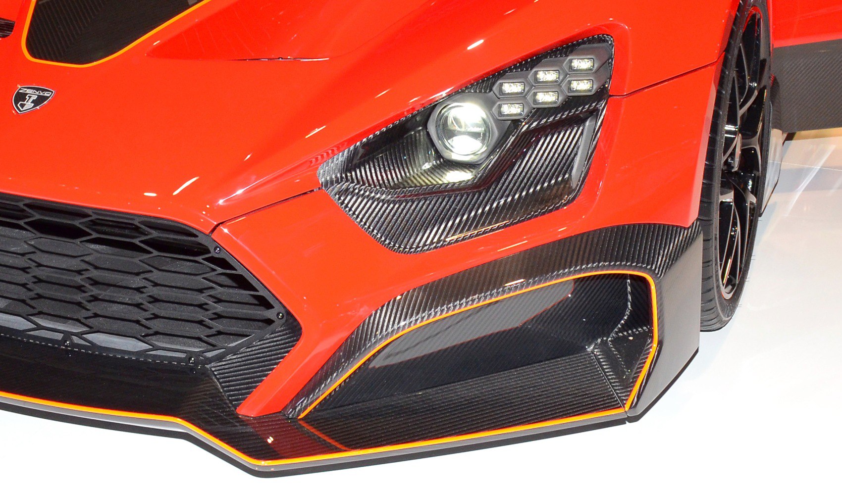 Close-up of front headlight and carbon fiber aerodynamic trim