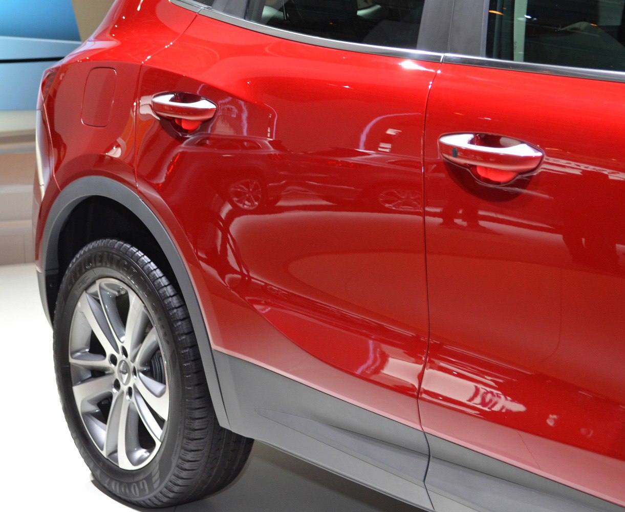Close-up of rear side door and alloy wheel on red vehicle