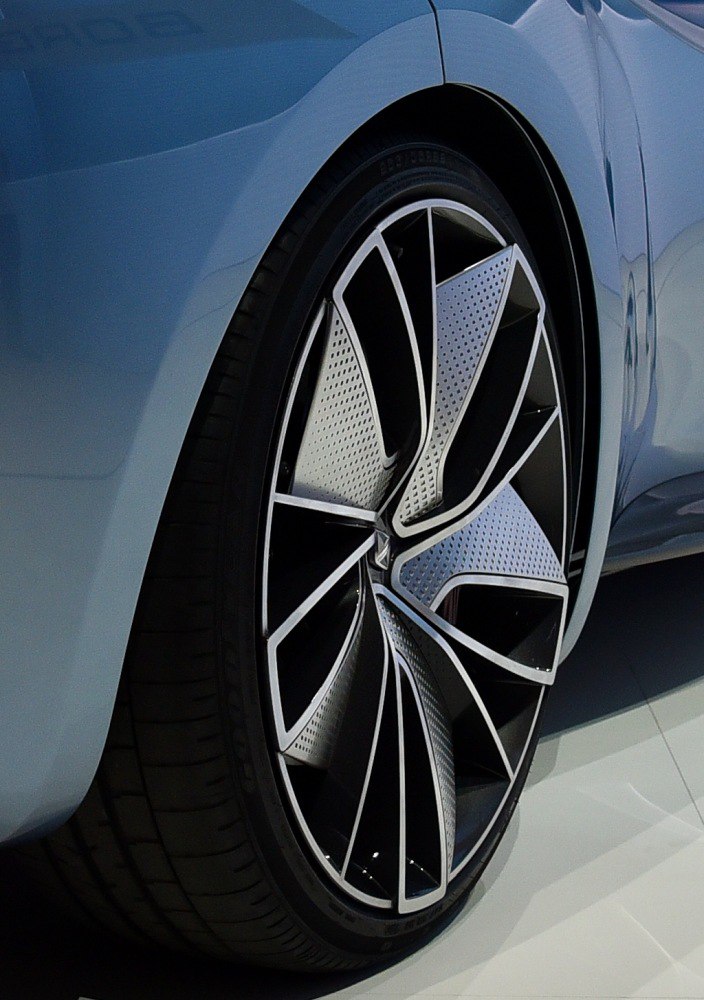 Close-up of a futuristic alloy wheel with intricate geometric patterns.