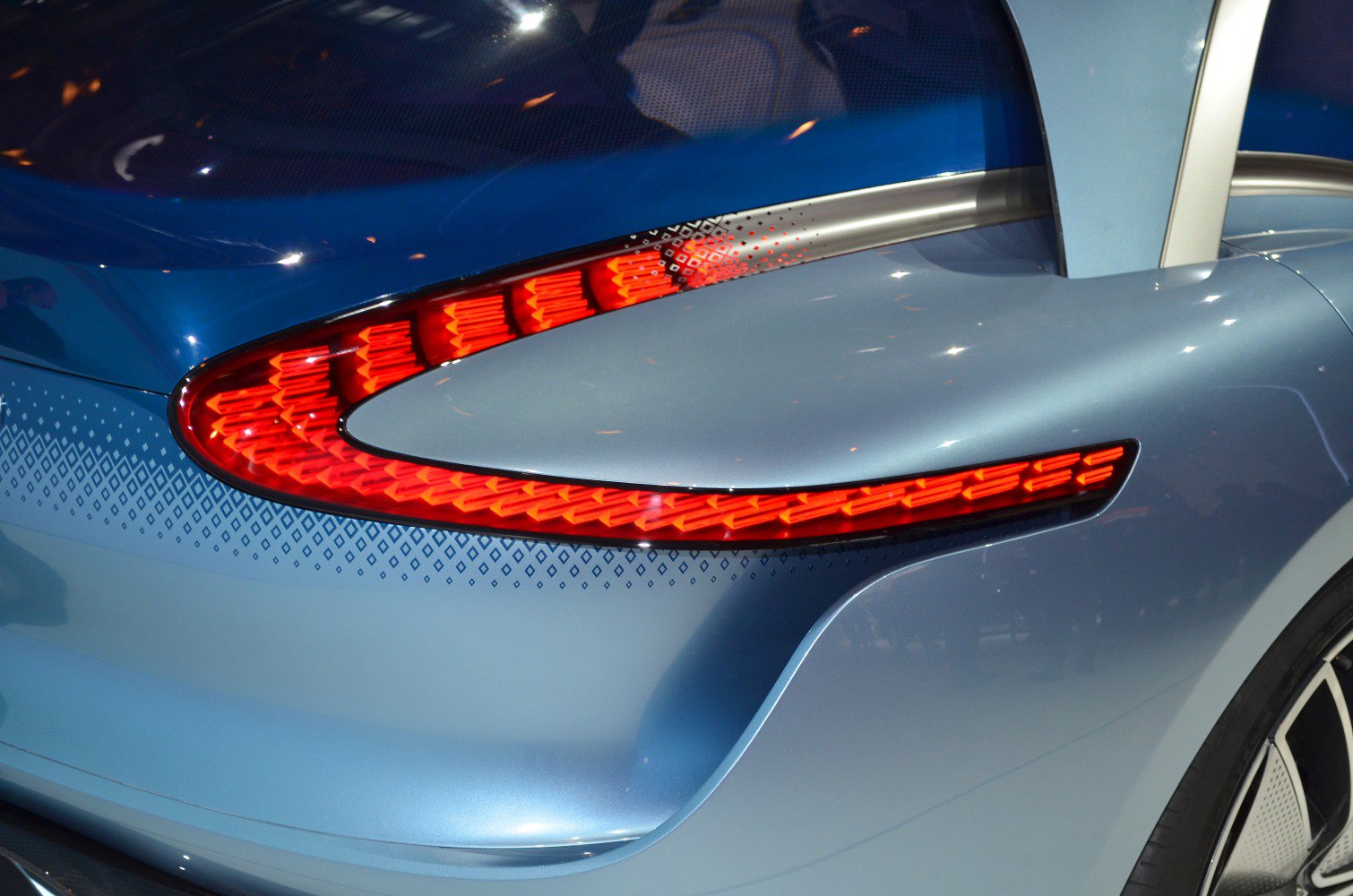 Rear LED taillight and sleek blue car body with window detail