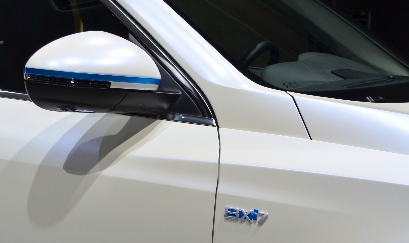 White side mirror with blue stripe and BXi7 badge on door panel