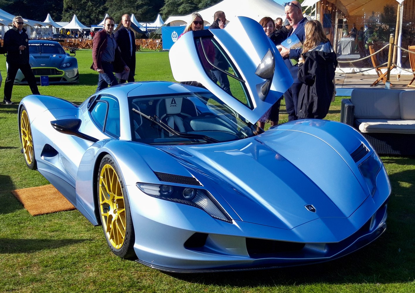Electric hypercar with upward-opening scissor door and yellow multi-spoke wheels