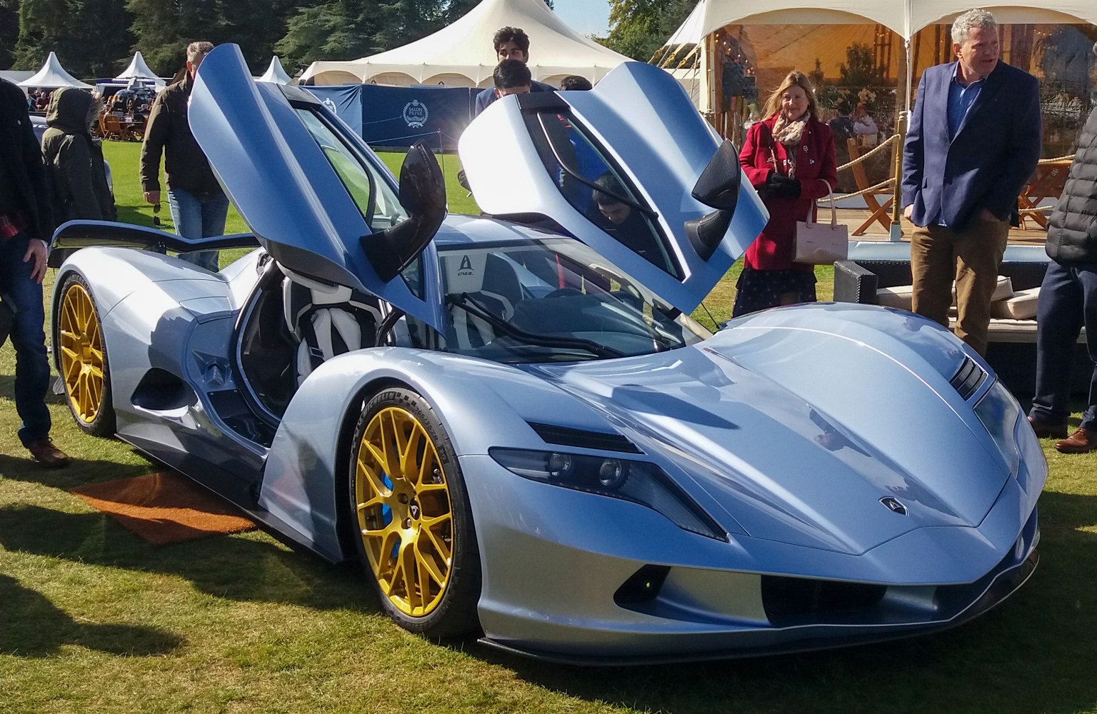 Electric hypercar with gullwing doors and gold-colored wheels