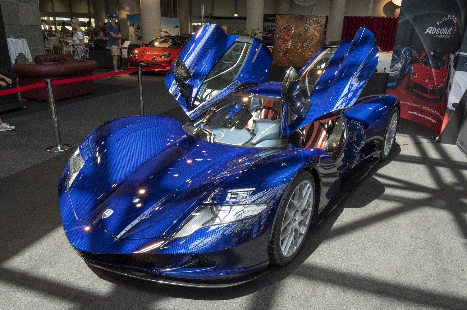 Blue hypercar with upward butterfly doors and aerodynamic body