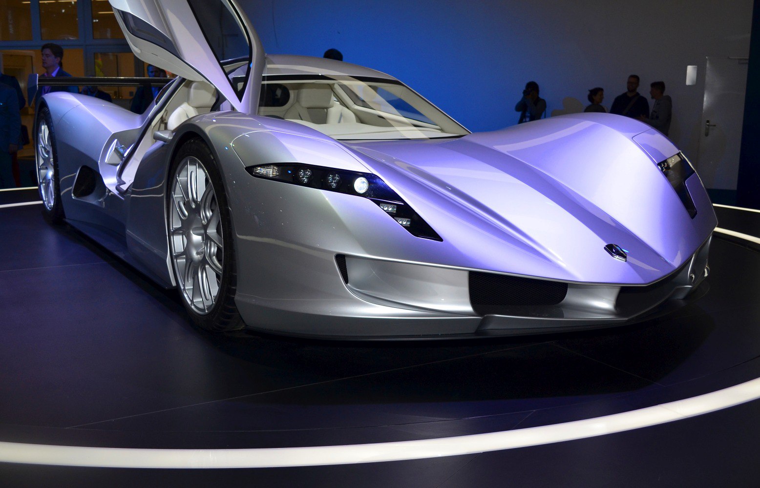 Futuristic silver sports car with butterfly doors and sharp headlights