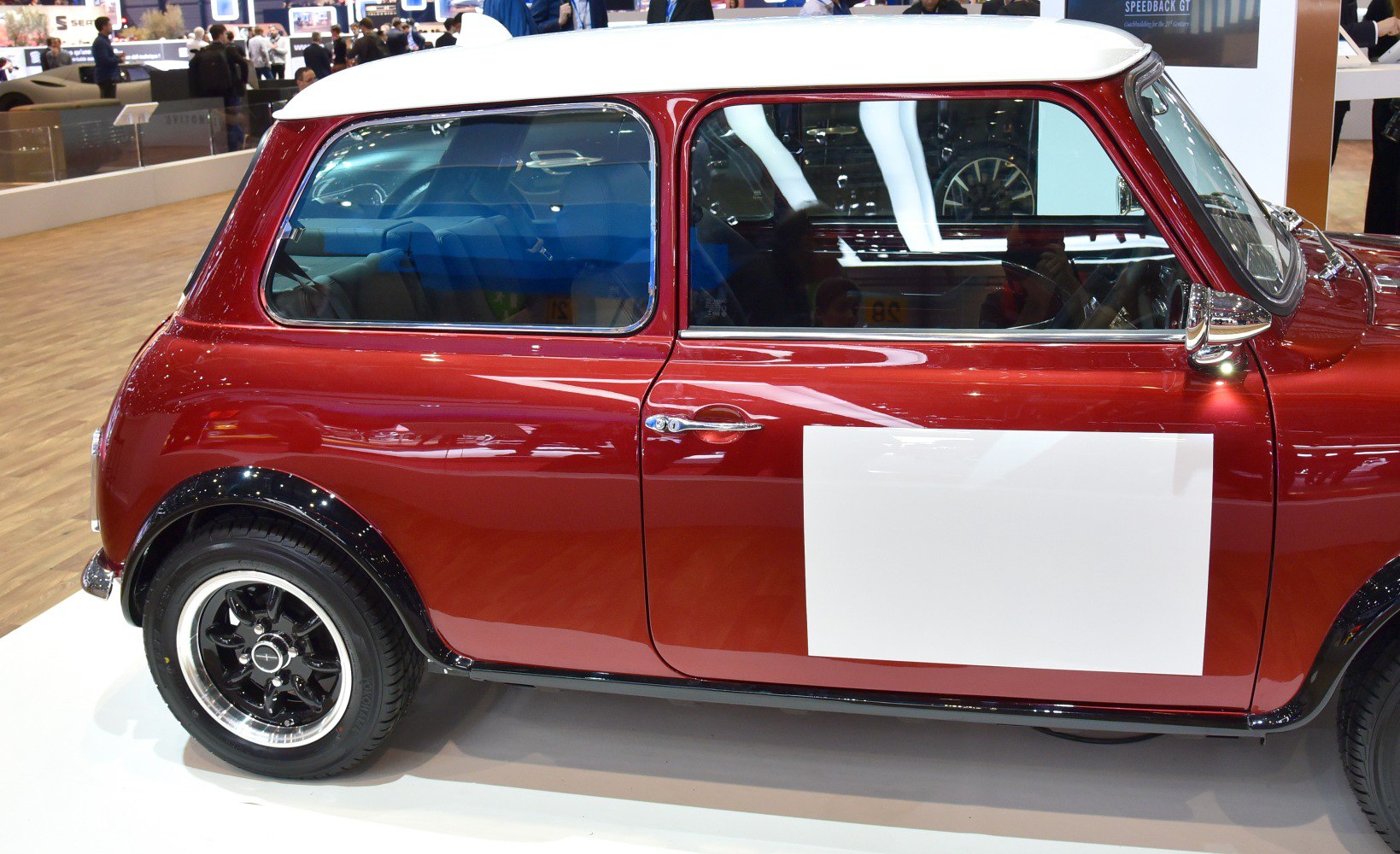 Side profile of compact car with black and chrome wheels