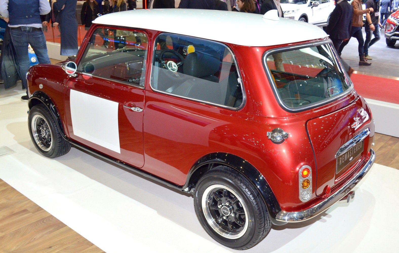Two-tone red and white compact retro-style car with rally decal and black rims