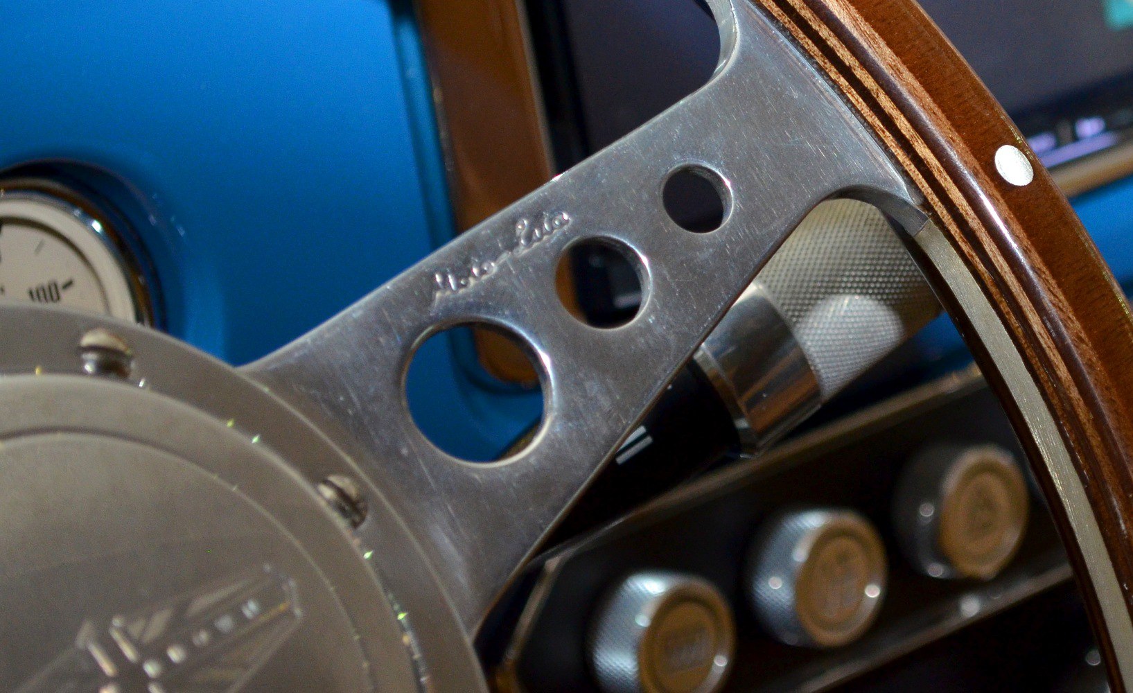 Close-up of vintage wooden steering wheel and dashboard controls