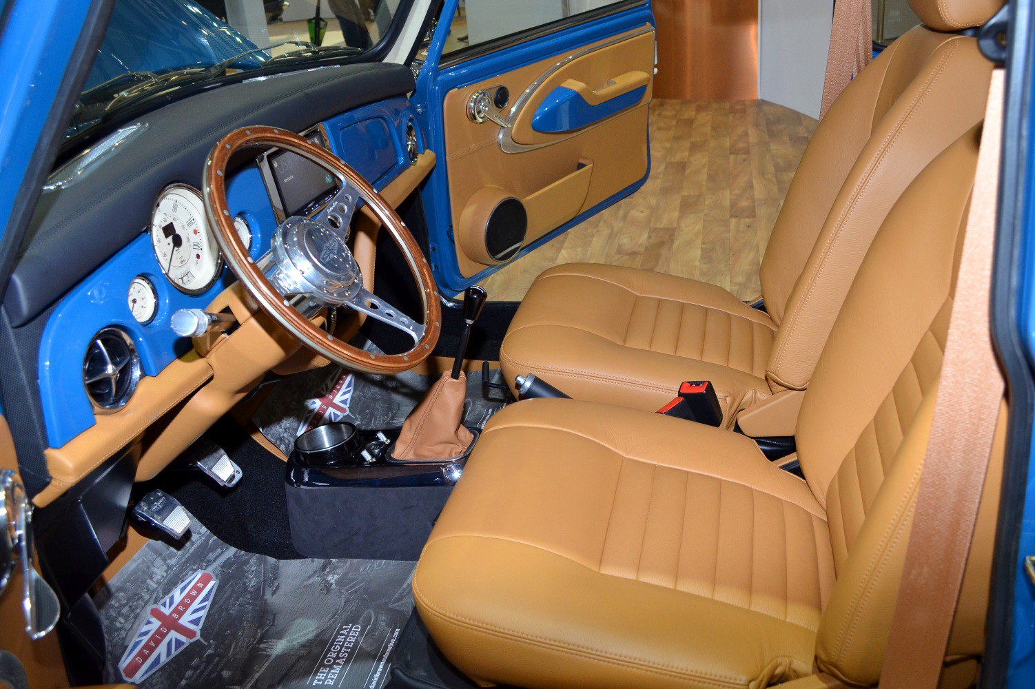Tan leather seats and classic wood steering wheel with manual gear shift