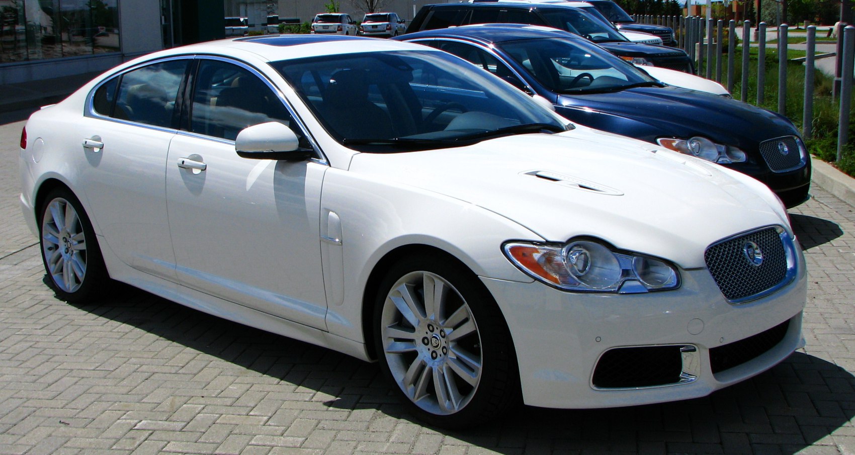 Luxury sedan with alloy wheels and hood vents front side view