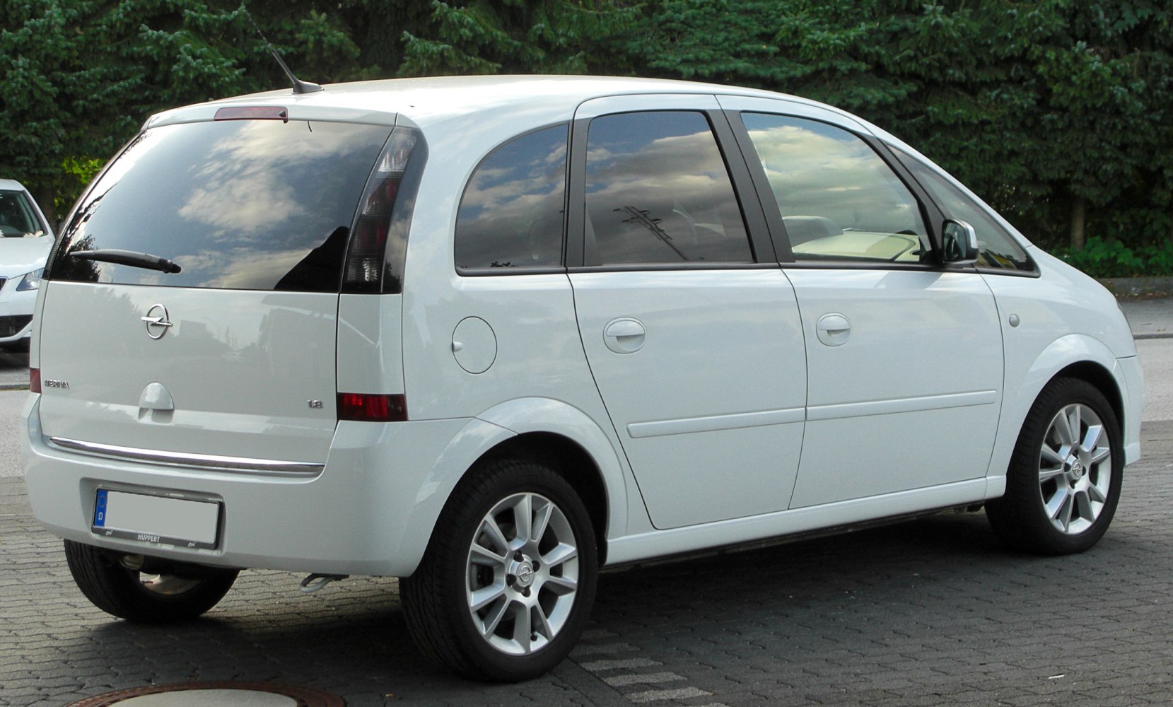 Rear and side view of a white compact MPV with tinted windows and alloy wheels