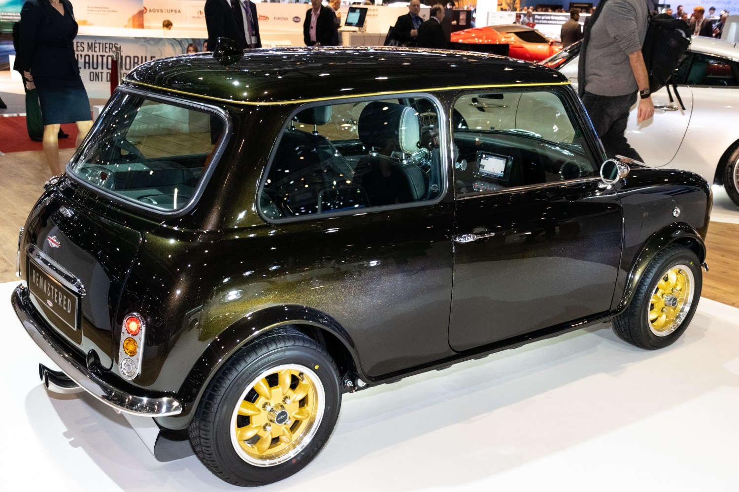 Compact classic-styled car with gold alloy wheels and glossy dark finish
