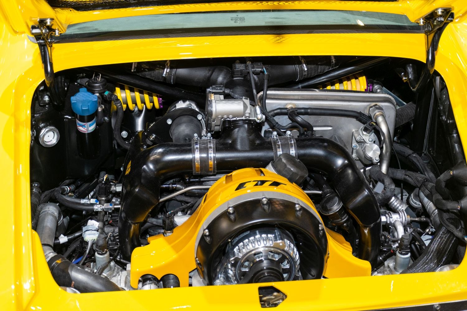 Detailed engine bay with visible suspension coil and yellow engine cover