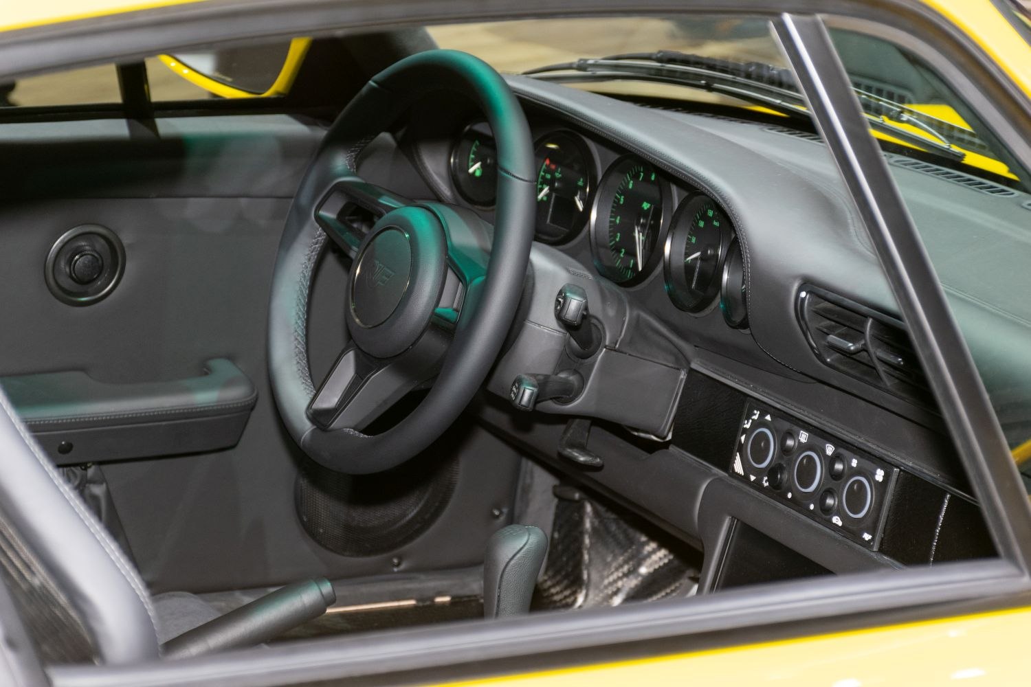 Close-up of car dashboard, steering wheel, and gauges.