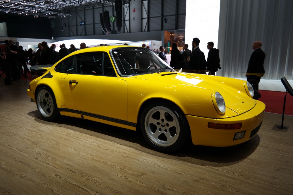 Yellow classic sports coupe with wide rear wing and round headlights