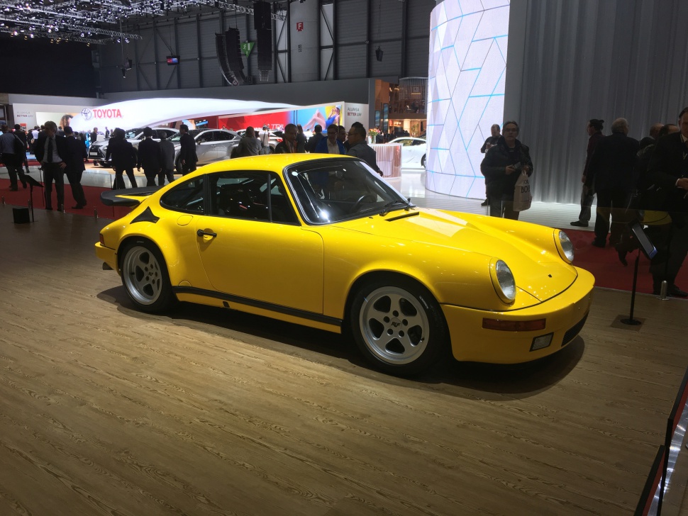 Yellow classic sports coupe with wide rear wing and deep-dish alloy wheels