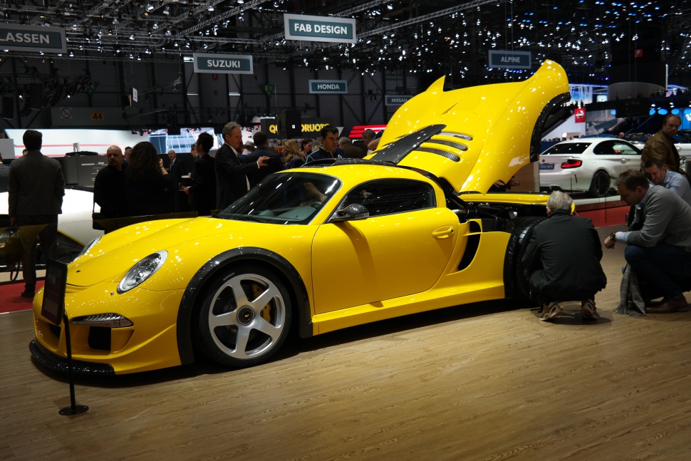 Yellow sports coupe with rear engine lid open and aerodynamic vents