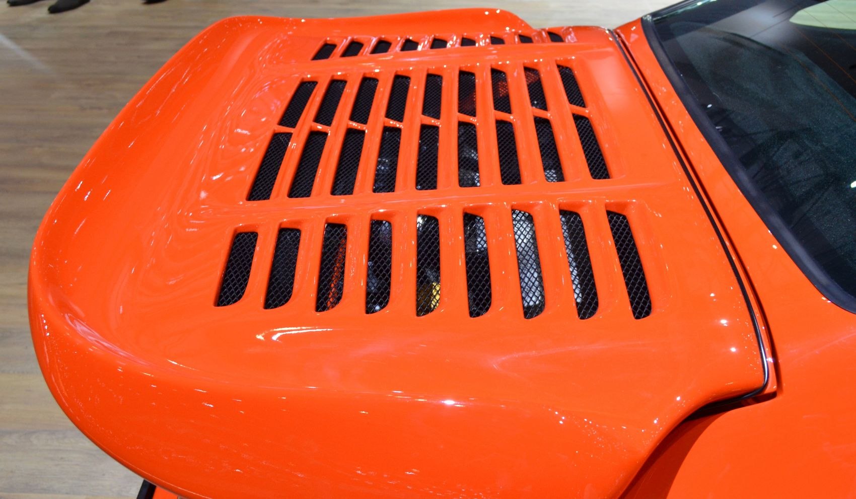 Close-up of bright orange engine cover vent slots and rear window edge