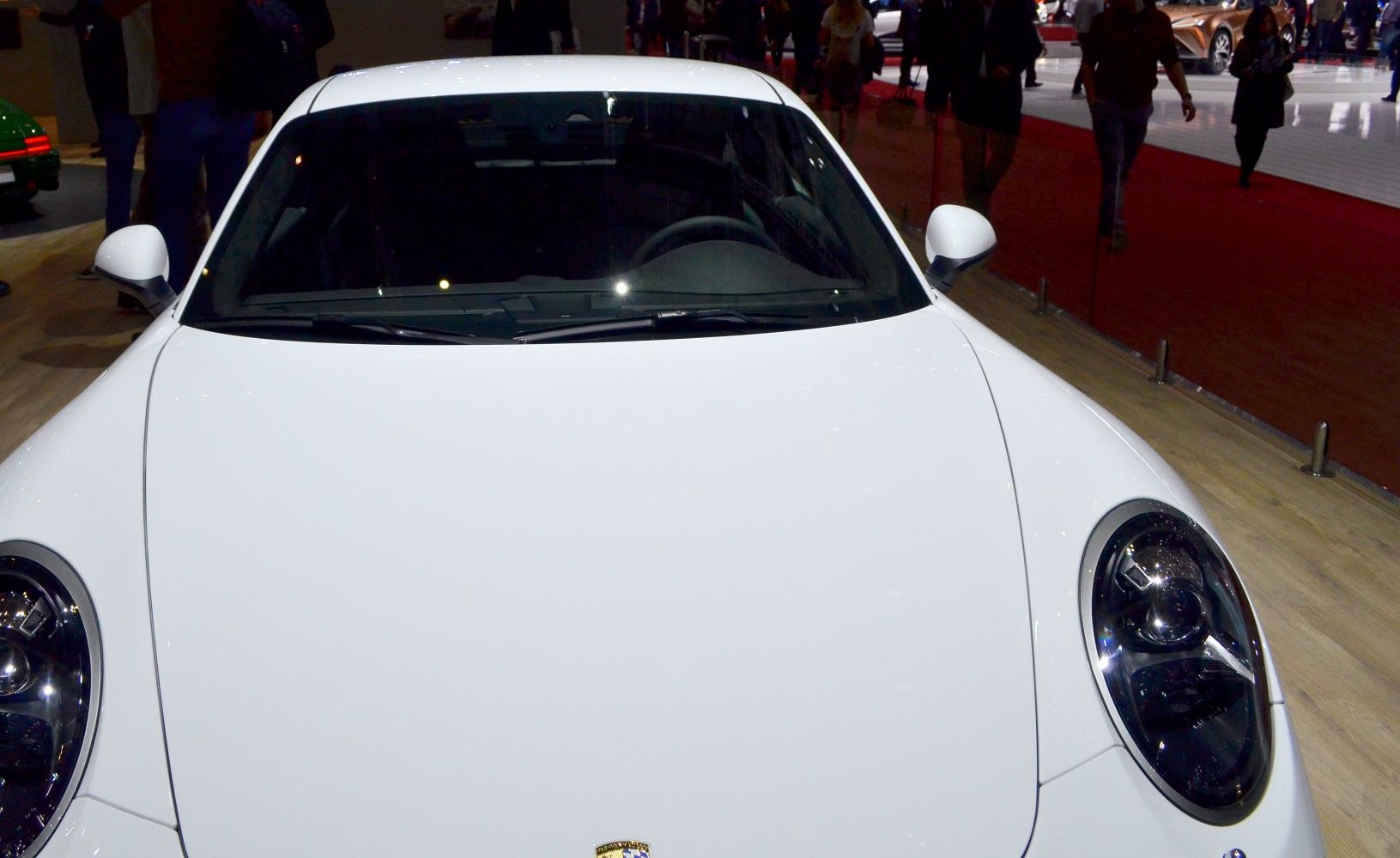 Smooth hood and round headlights of a white sports coupe