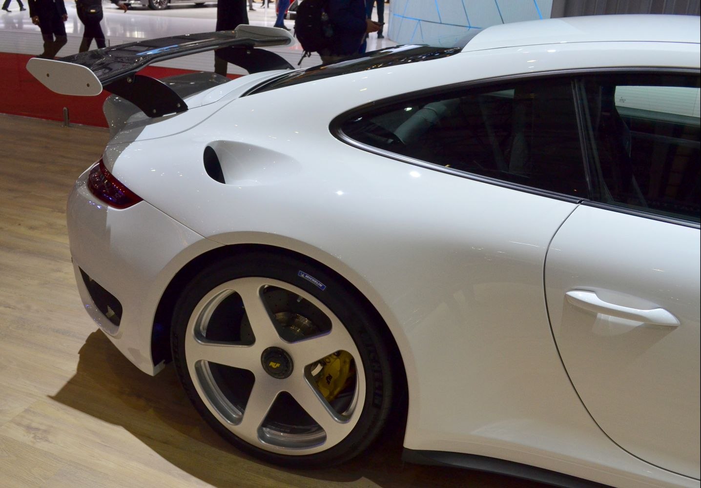 Rear side with large aerodynamic wing and five-spoke wheel.