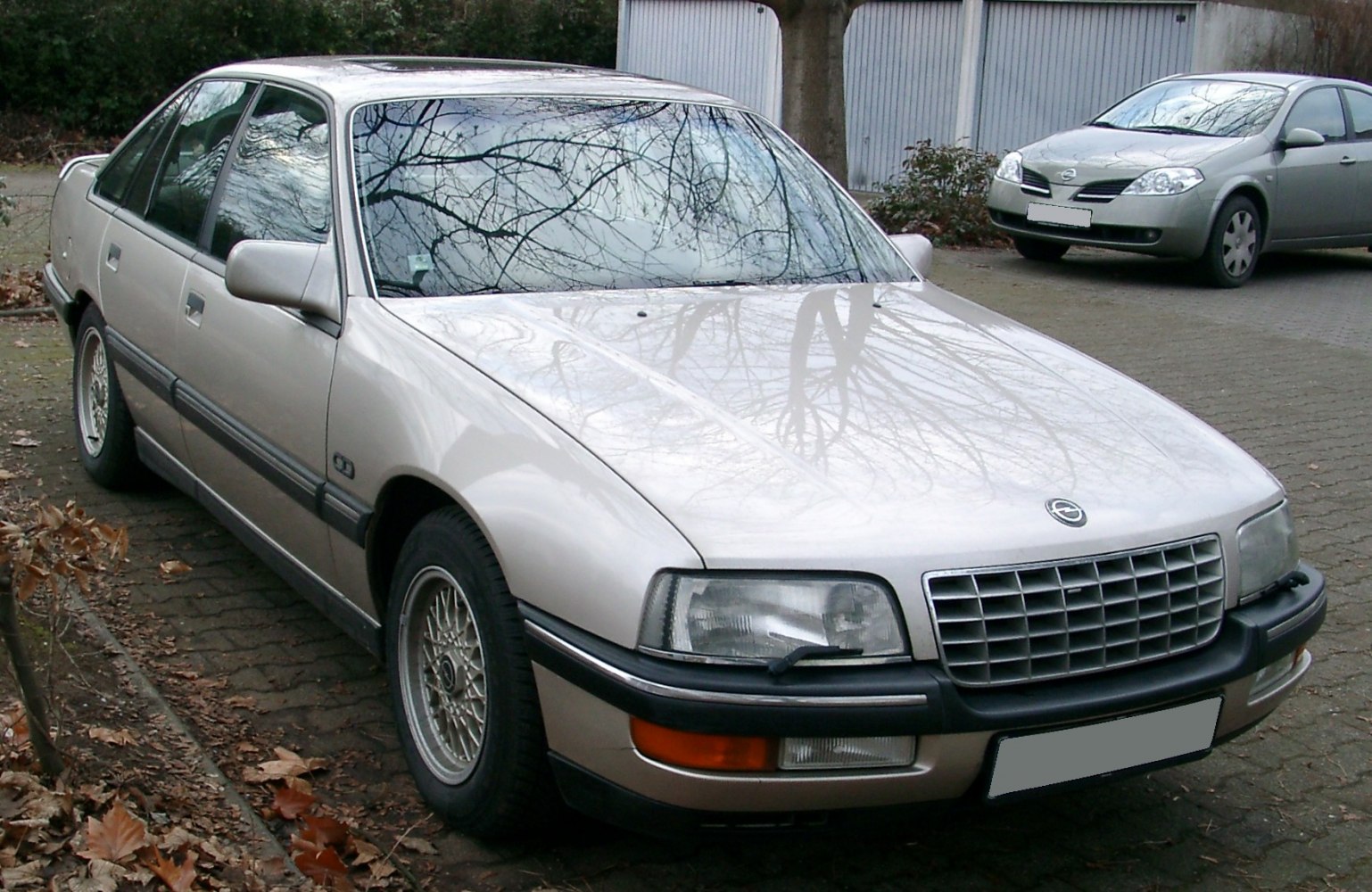 Front side view of sedan with mesh wheels and headlight washers