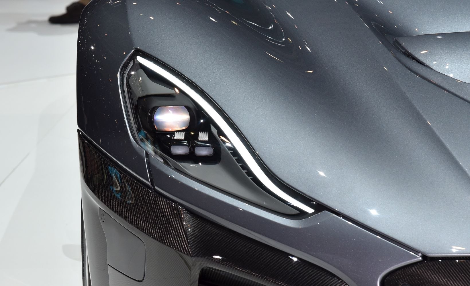 Close-up of futuristic headlight and carbon fiber front panel