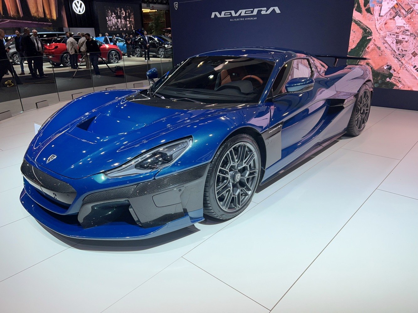 Sleek blue electric hypercar with aerodynamic front and carbon fiber accents