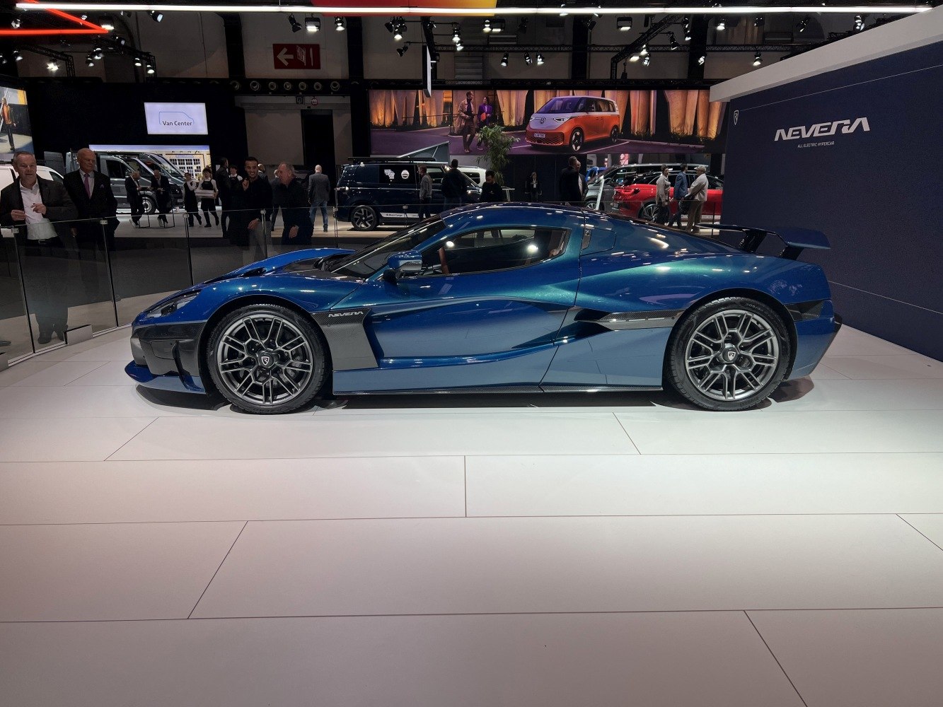 Side profile of a sleek blue electric hypercar with aerodynamic body and alloy wheels.