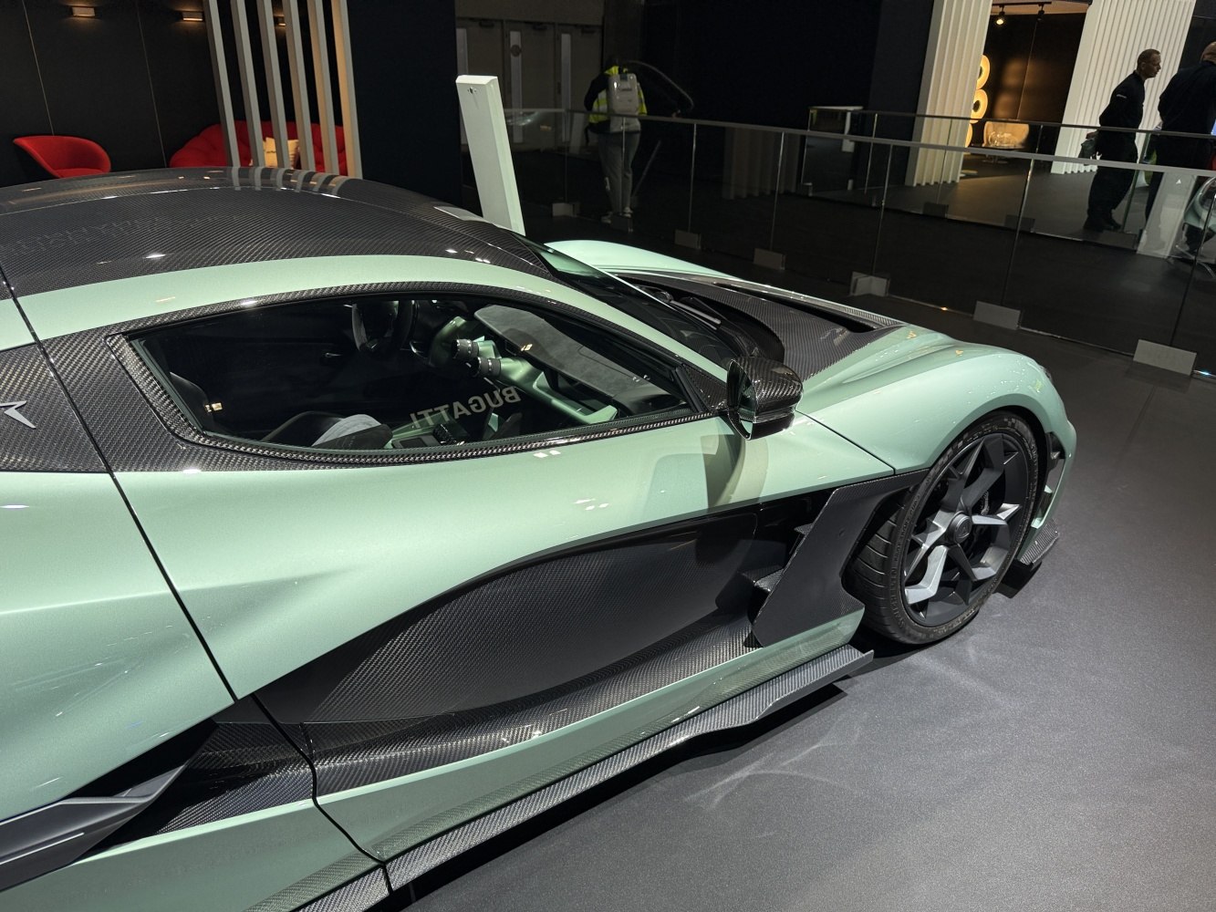 Side profile of sleek electric hypercar with carbon fiber panels and aerodynamic design