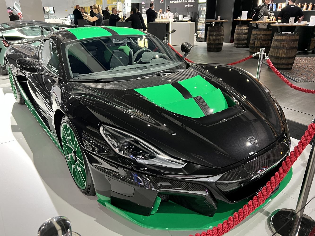 Front view of a sleek electric sports car with green accents and aerodynamic carbon fiber details
