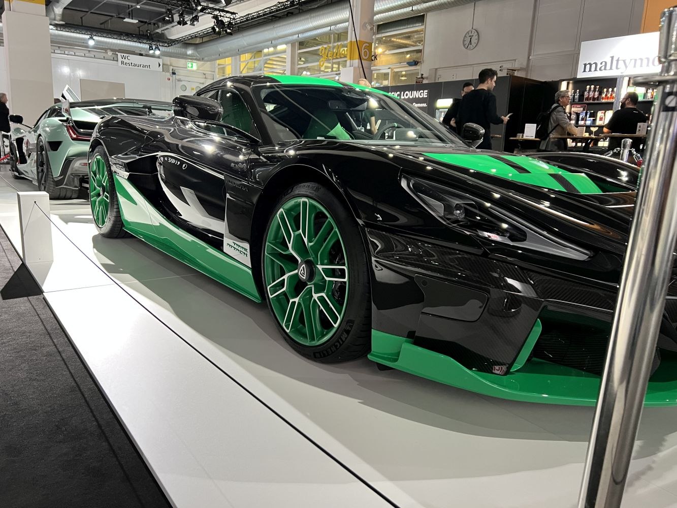 Aerodynamic sportscar front with black and green body and green alloy wheels