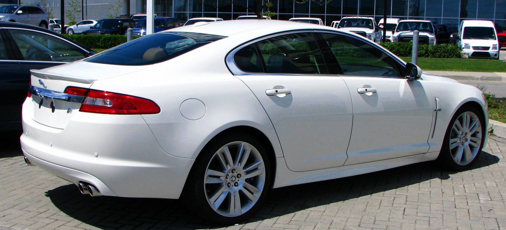 White luxury sedan showcasing rear side profile and alloy wheels
