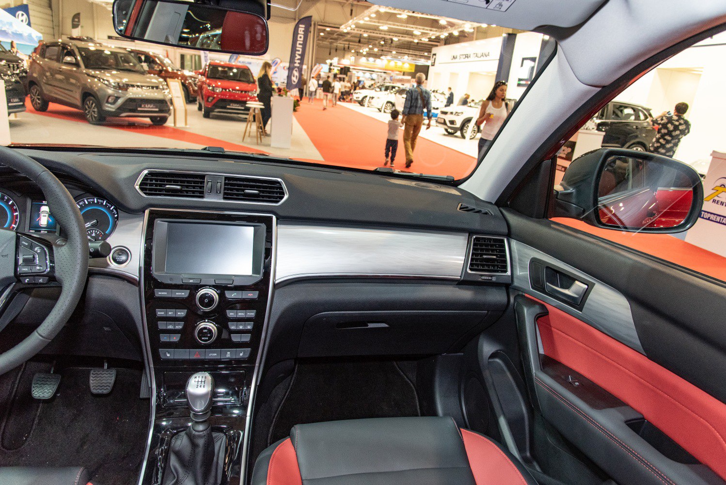 Manual transmission cockpit with touchscreen and red-black upholstery