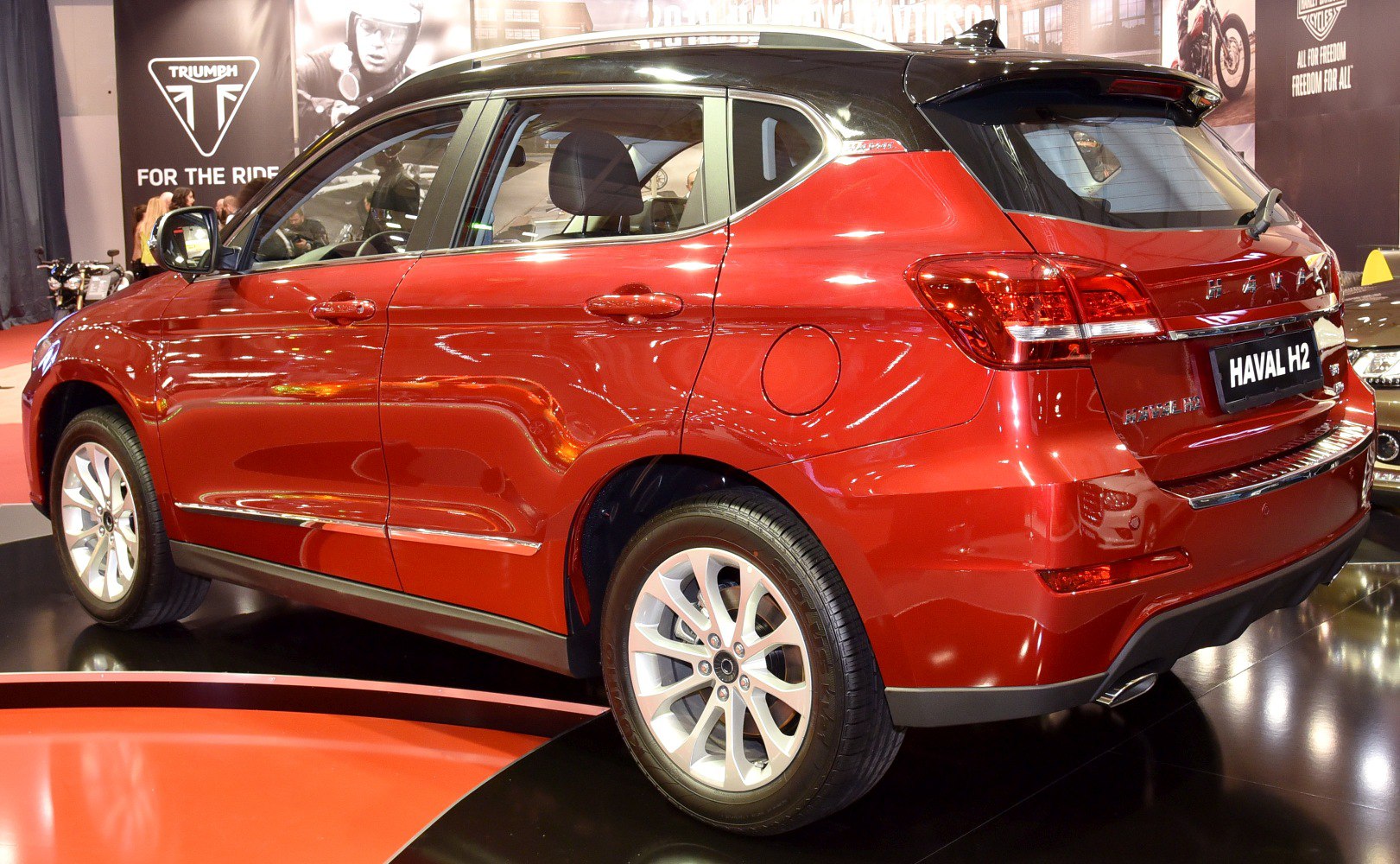 Red compact SUV rear side view with alloy wheels and black roof