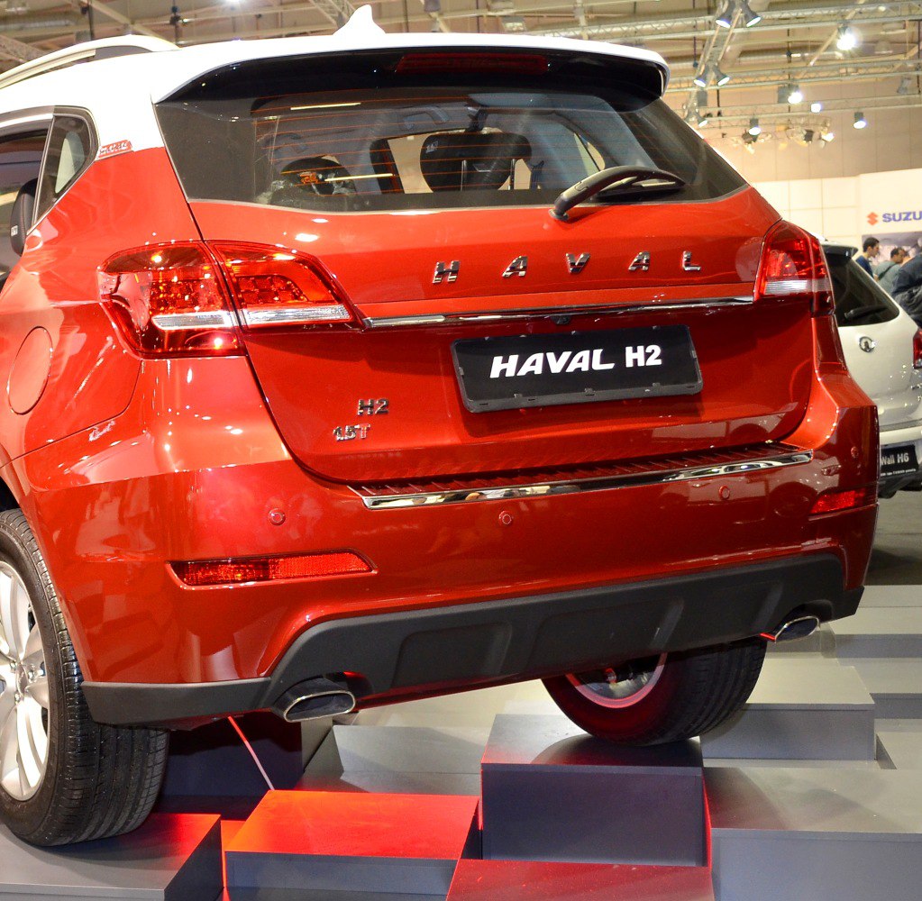 Rear of red SUV with dual exhausts, distinctive tail lights, and rear windshield wiper
