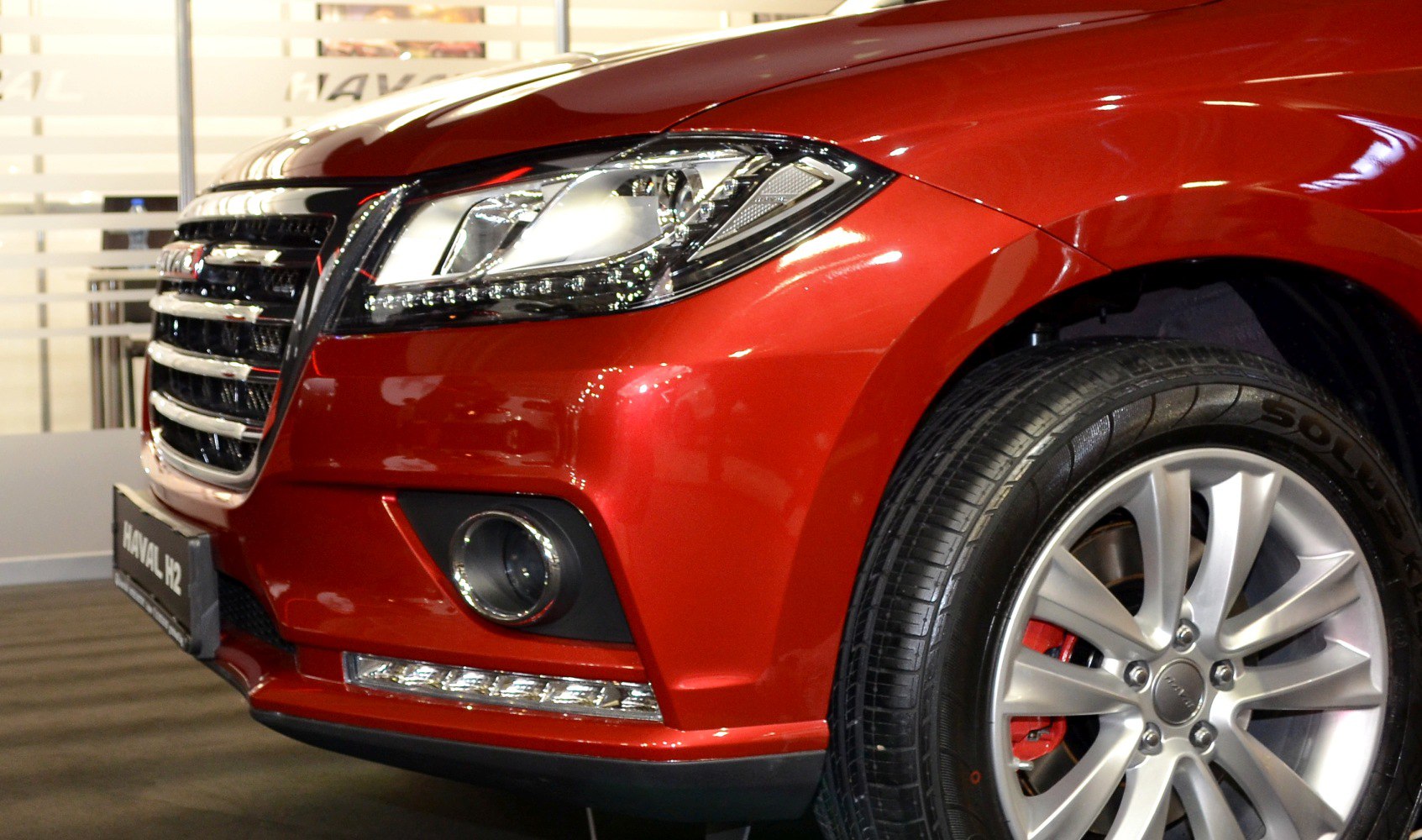 Close-up of front grille, headlight, fog lamp, and alloy wheel