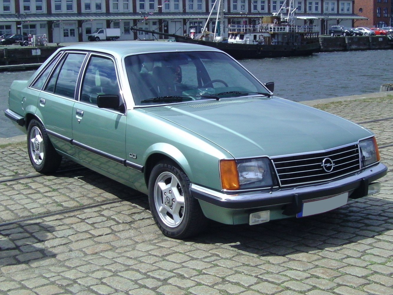 Side-front view of vintage sedan with classic rectangular headlights and multi-spoke wheels