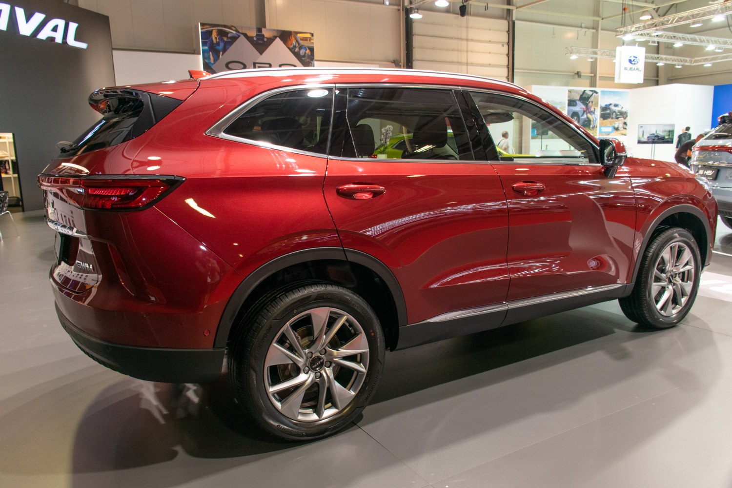 Rear side profile of red mid-size SUV with alloy wheels and tinted windows