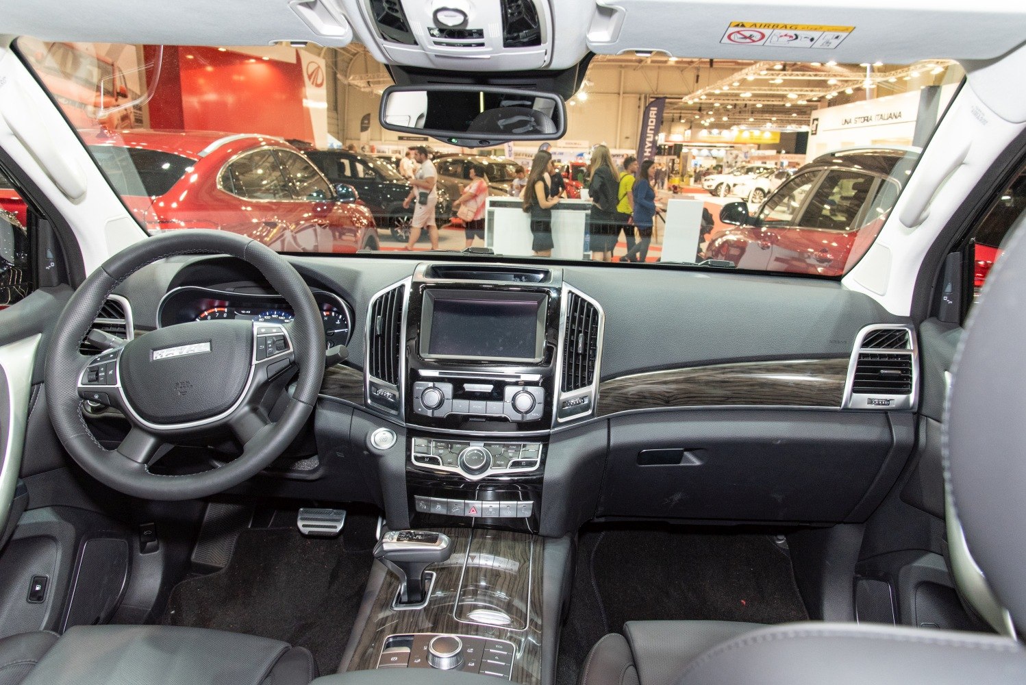 Interior dashboard and steering wheel with infotainment display and wood trim