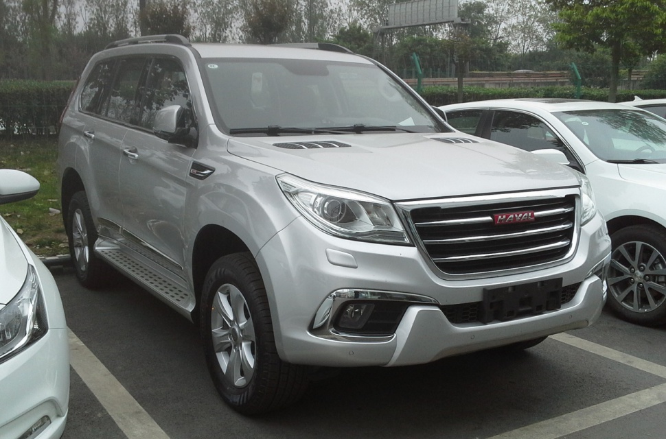 Silver SUV with chrome grille and side steps parked outdoors
