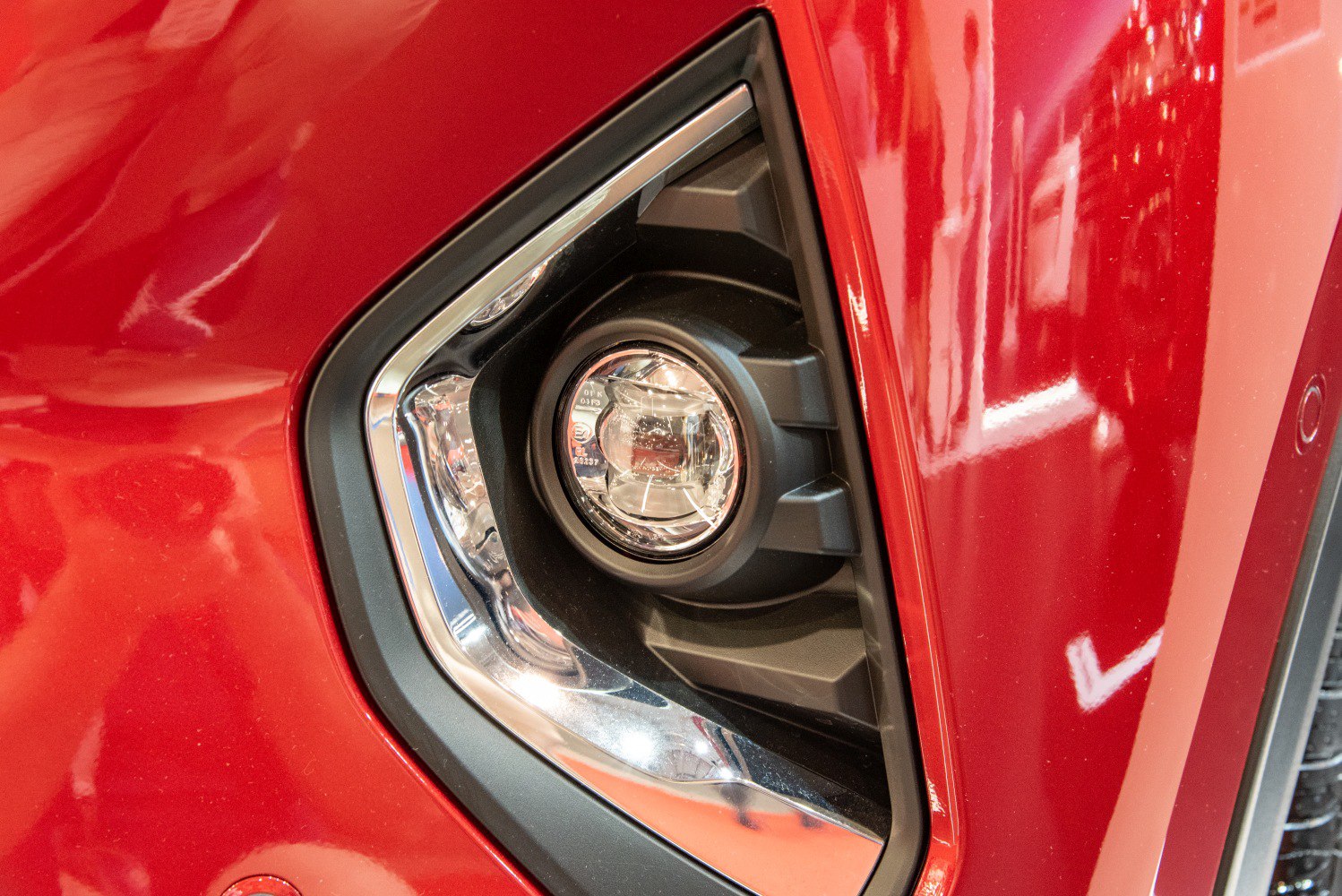 Close-up of fog light surrounded by chrome trim