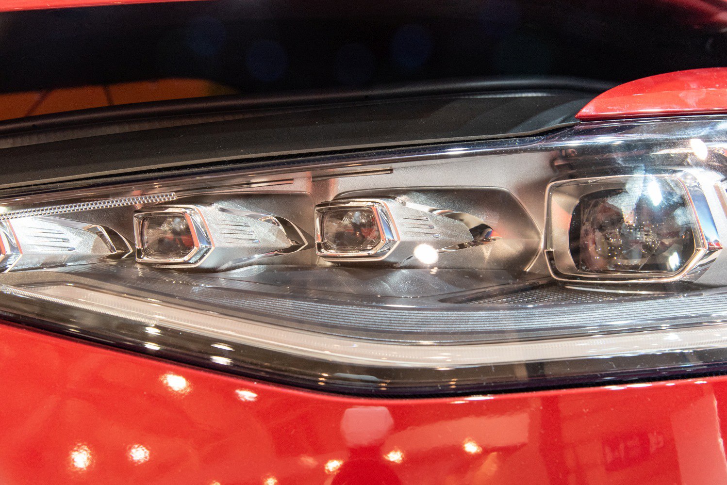 Close-up of LED headlight unit with chrome accents and projector lenses