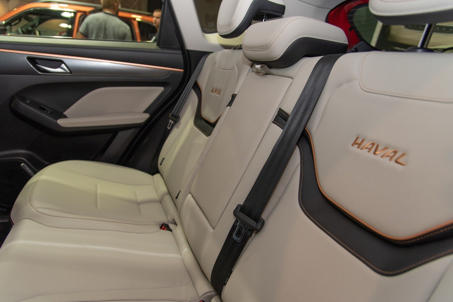 Beige leather rear seats with seatbelt and elegant stitching