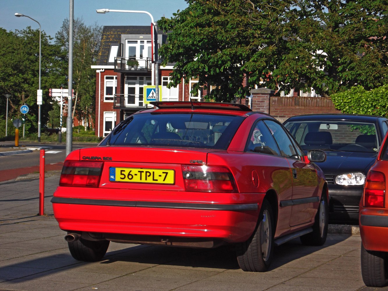 Rear view of red coupe with sunroof and distinctive taillights